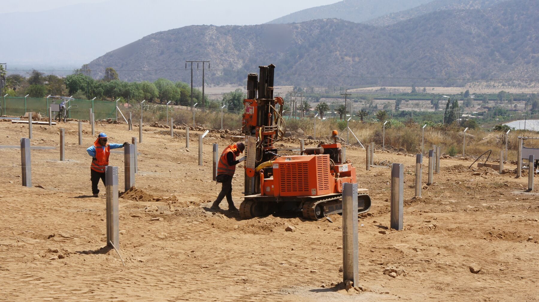 Crew installing mounting posts during solar farm construction